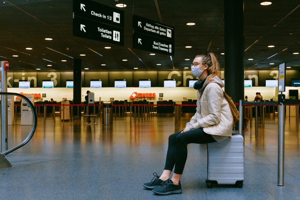 Passageira com máscara aguardando no aeroporto