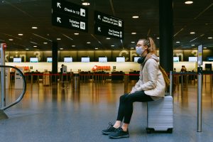 Passageira com máscara aguardando no aeroporto